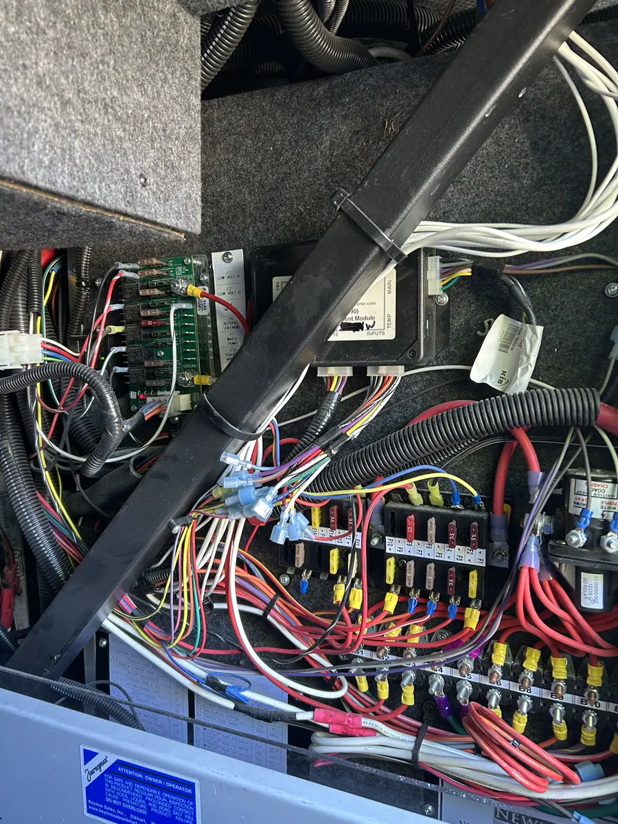 Complex Newmar RV electrical distribution bay with fuse blocks, control modules, and dense wiring harnesses.